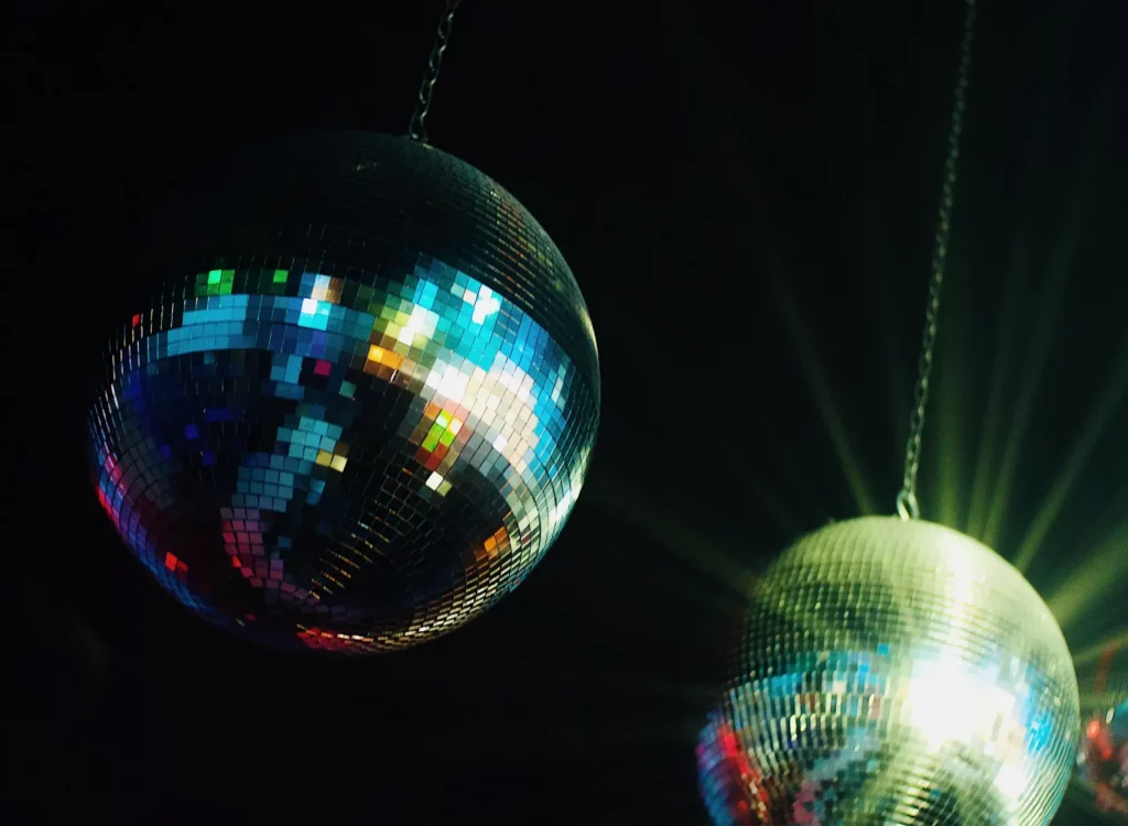 Two large mirrorballs hanging from a ceiling